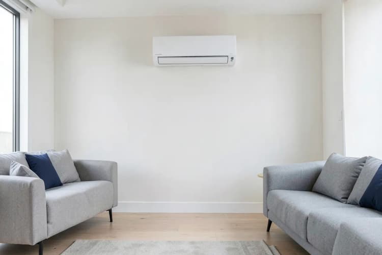 Um espaço de sala de estar com um local ideal marcado para a instalação de um ar-condicionado na parede.